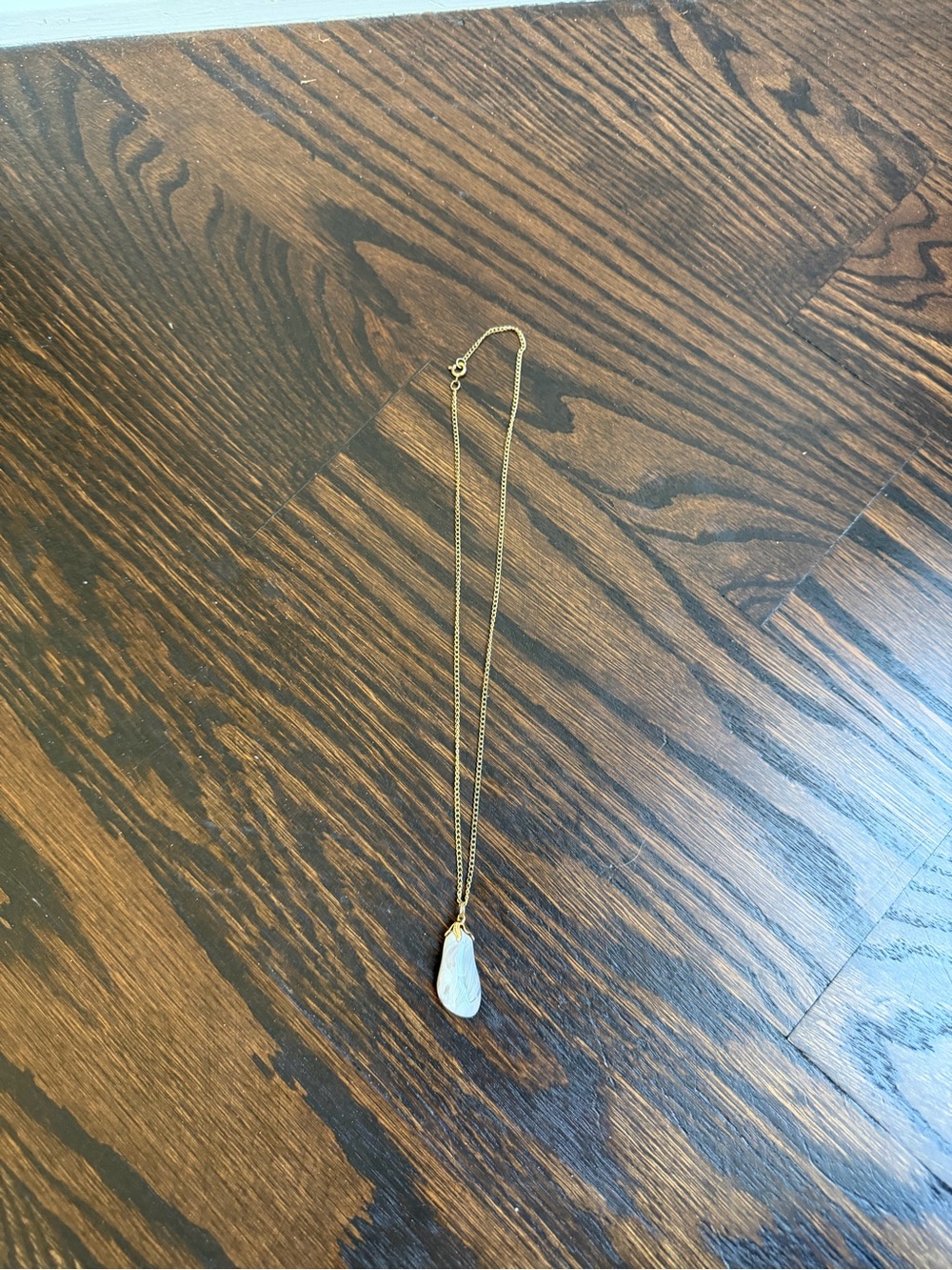 Gold-toned necklace featuring a polished agate pendant